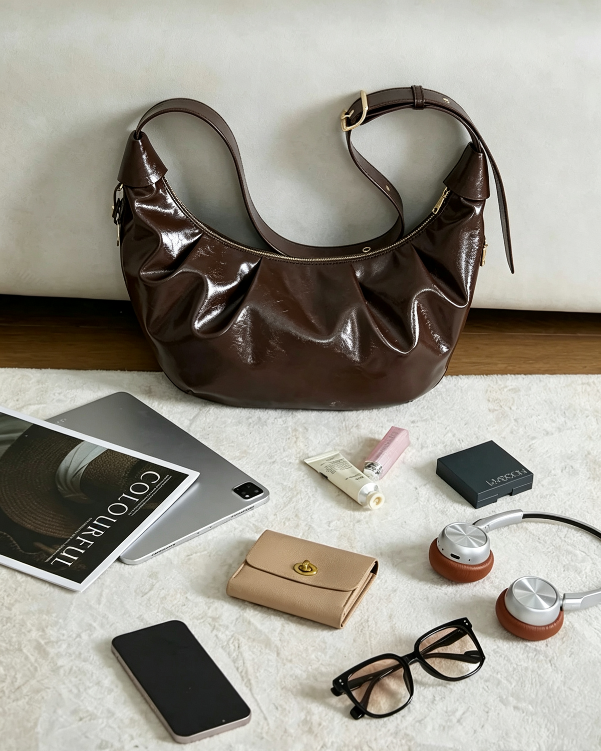 Brown crescent shoulder bag styled with everyday essentials