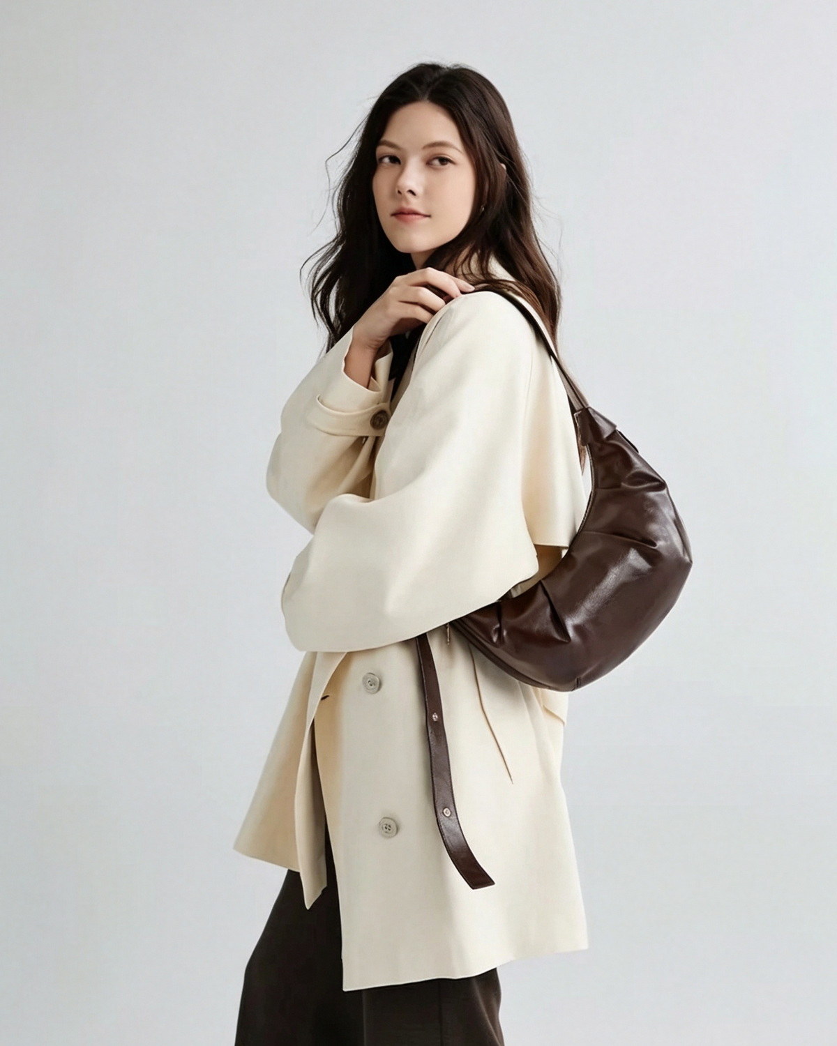 Brown crescent shoulder bag styled with everyday essentials
