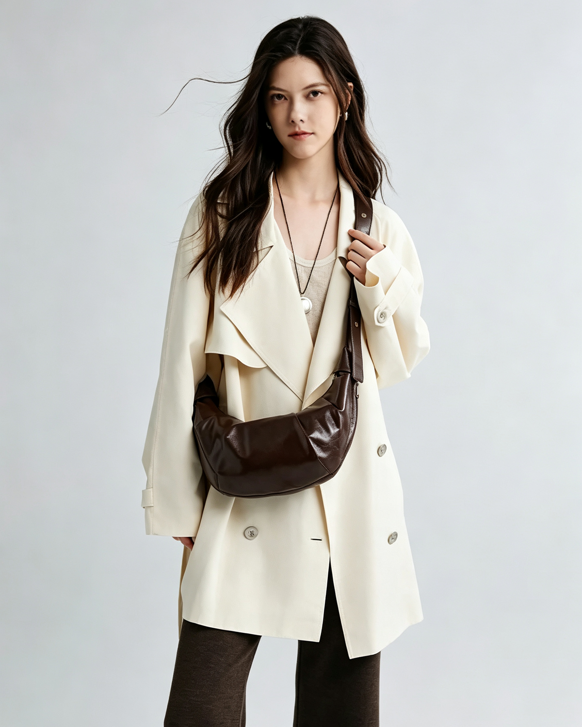 Brown crescent shoulder bag styled with everyday essentials